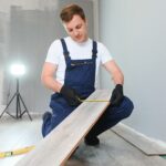Repairman laying laminate flooring at home